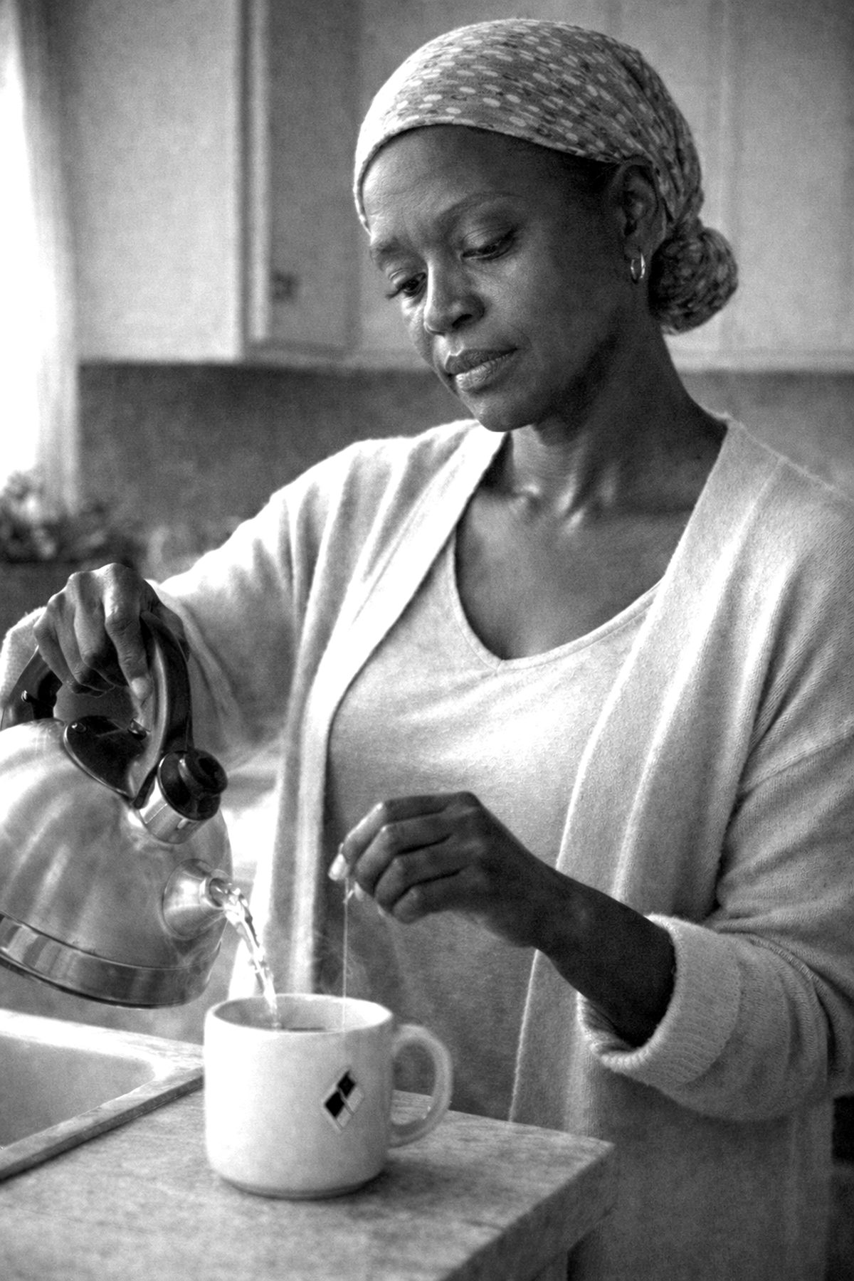 Mariah pouring tea at her kitchen counter in the early morning.